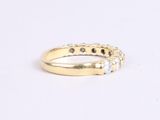 a close up of a yellow gold ring with three diamonds
