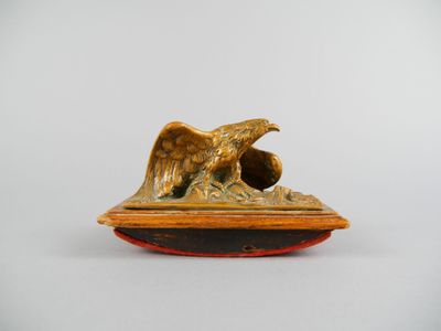 une image représentant une statue d'aigle posée sur un socle en bois