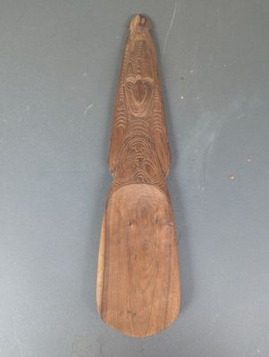 une pagaie en bois accrochée au mur