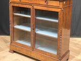 an antique oak bookcase with glass doors and drawers