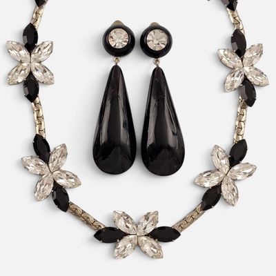 un gros plan d'un collier et de boucles d'oreilles sur fond blanc