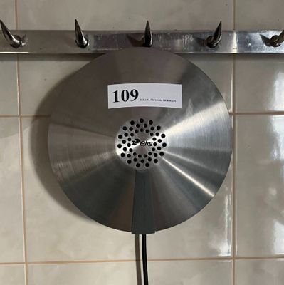 un grand disque métallique accroché au mur d'une salle de bains
