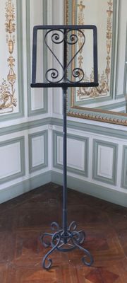 un pied métallique surmonté d'un miroir dans une pièce