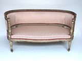 un canapé à l'ancienne dont l'assise est recouverte d'un tissu rayé rouge et blanc