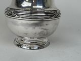 a silver vase that is sitting on a table