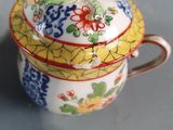 a small cup with a lid that has a flower design on it