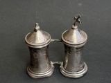 pair of silver salt and pepper shakers on a black surface