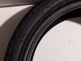 a close up of a tire on the side of a white wall