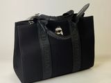 the black handbag is sitting on a white surface with a white background