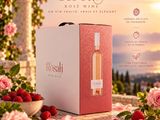 une bouteille de vin rosé à côté d'un bol de fraises et de roses