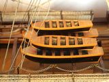 four small wooden boats on display in a museum