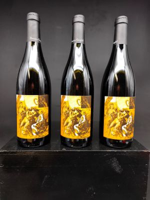 trois bouteilles de vin posées sur un bloc de bois
