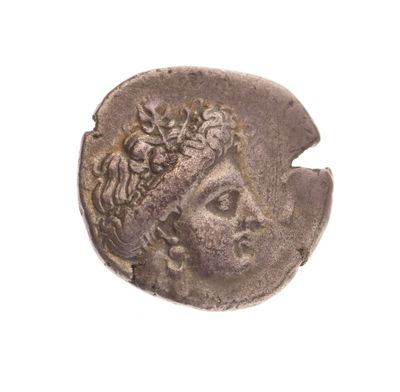 une vieille pièce de monnaie sur laquelle figure le visage d'une femme, sur un fond blanc