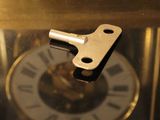 a clock that has a key in the middle of it