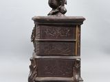 an antique wooden chest of drawers with a bird on top