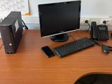 un bureau sur lequel se trouvent un ordinateur, des haut-parleurs et un clavier