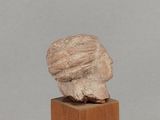 an image of a sculpture of a head on a wooden block