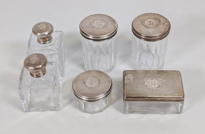 quatre bocaux en verre avec des couvercles argentés, posés sur une surface blanche