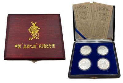a wooden box with four silver coins in it