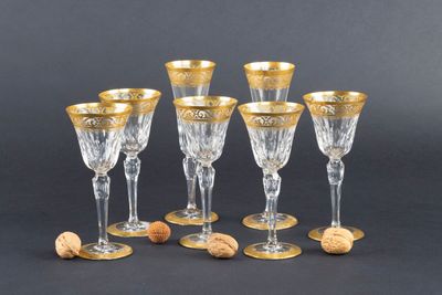 six verres à vin aux bords dorés et ornés de bouchons, sur fond noir