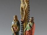 statue représentant un crucifix avec Jésus sur la croix et une femme tenant un enfant dans ses bras