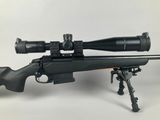 a rifle on a tripod with a scope on it