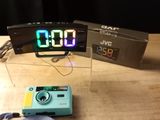 a small camera and a digital clock on a table