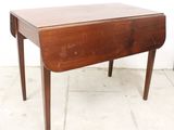 a small wooden table with a drop leaf on it
