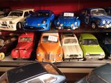 beaucoup de petites voitures sur une étagère dans une pièce