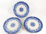 three blue and white plates on a white background