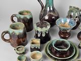 many pieces of pottery that are sitting on a table