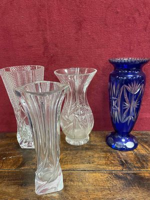 trois vases en verre posés sur une table près d'un mur rouge