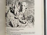 an open book with a drawing of a man on a rock
