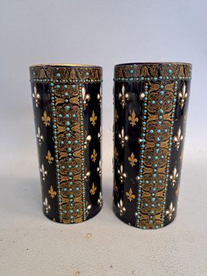 pair of black and gold vases with blue and white designs