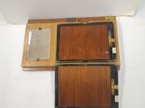 une vieille boîte en bois contenant un miroir, posée sur une surface blanche