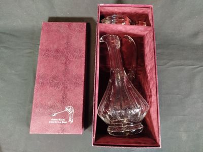 un vase en verre dans une boîte rose posée sur une table