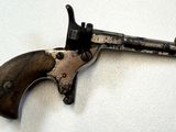 un pistolet posé sur une surface blanche, avec un fond blanc