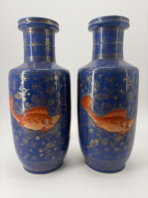 deux vases décorés de poissons, posés sur une table