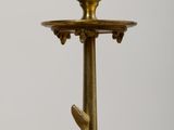 a gold colored candle holder with a bird on it