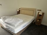 a bed with a white comforter on it in a room