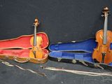 two violin cases sitting next to each other on a black surface