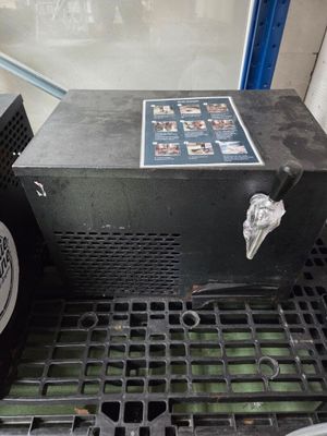 une photo d'une machine à café posée sur une grille métallique