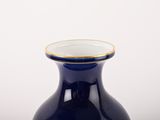 a blue vase with a gold rim sitting on a table