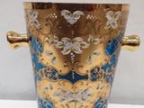 a blue vase with a gold handle on a white table