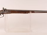 fusil exposé sur un socle en acrylique transparent, sur fond blanc