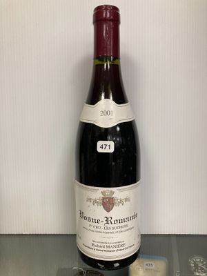 une bouteille de vin posée sur une table à côté d'un verre de vin