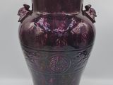 un vase violet posé sur une table blanche