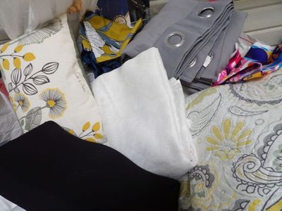 un tas de vêtements posé sur un lit près d'une fenêtre