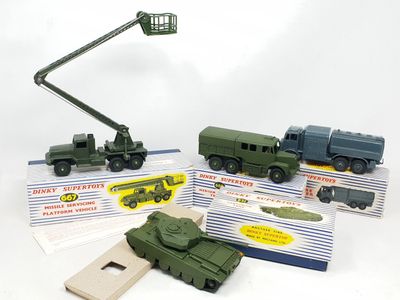 un véhicule militaire miniature équipé d'une grue, à côté d'autres véhicules miniatures