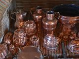 a lot of copper items on a wooden table